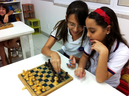 Jogo de xadrez para crianças shool kid jogando xadrez na sala de